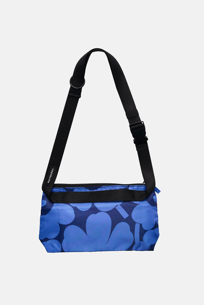 Blue patterned bag with a black strap on a light gray background